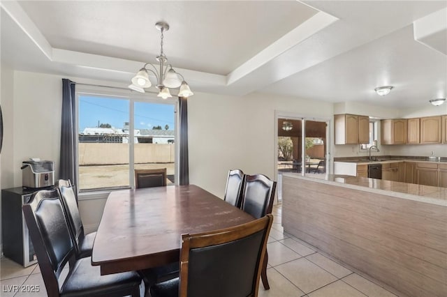 dining room featuring light tile patterned floors, an inviting chandelier, and a tray ceiling