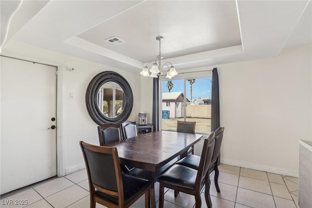 dining space featuring visible vents, baseboards, a tray ceiling, light tile patterned flooring, and a notable chandelier