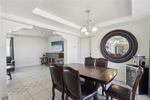 dining room featuring an inviting chandelier, a raised ceiling, light tile patterned floors, and baseboards