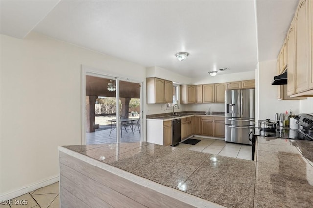 kitchen featuring light brown cabinets, a sink, stainless steel fridge, dishwasher, and tile counters