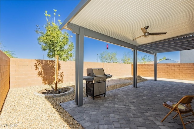 view of patio with ceiling fan, a fenced backyard, and grilling area