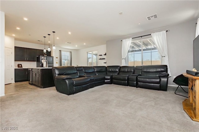 living room featuring recessed lighting, visible vents, light colored carpet, and a healthy amount of sunlight