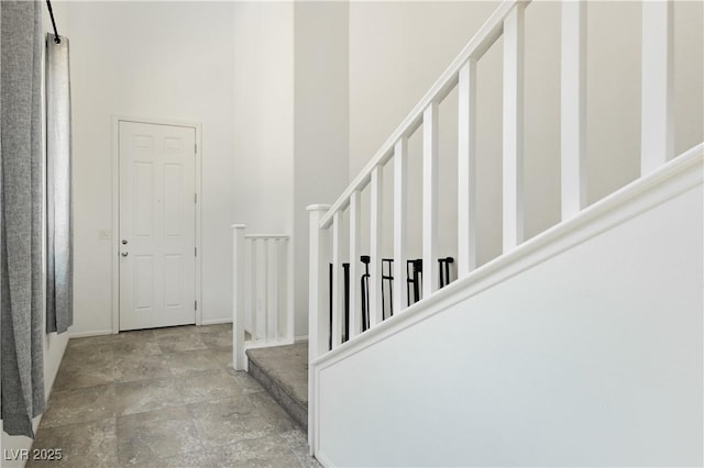 entrance foyer with stairway and a towering ceiling