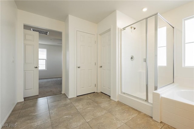 full bathroom featuring visible vents, baseboards, a bath, and a shower stall