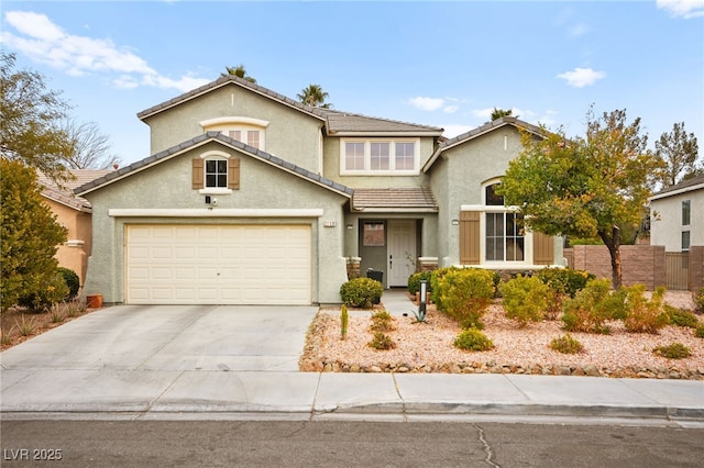 traditional-style house featuring stucco siding, fence, concrete driveway, an attached garage, and a tiled roof