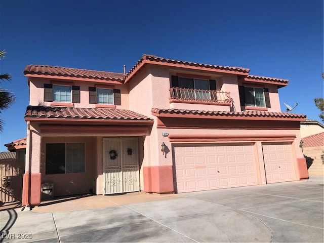 mediterranean / spanish-style home featuring a tile roof, concrete driveway, a garage, and stucco siding