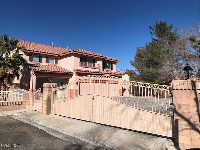 view of front of home with a tiled roof, a fenced front yard, stucco siding, and a gate