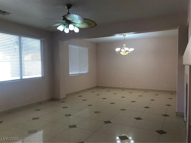 spare room with visible vents, ceiling fan with notable chandelier, and baseboards