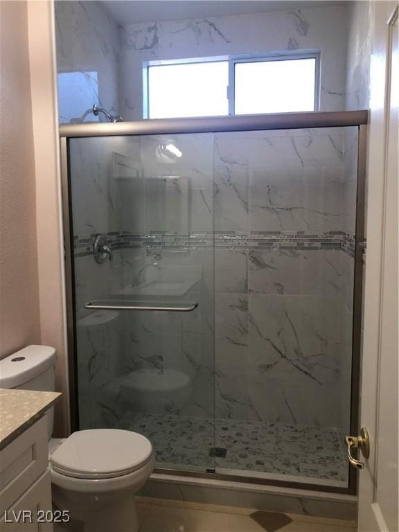 full bath featuring a marble finish shower, toilet, and vanity