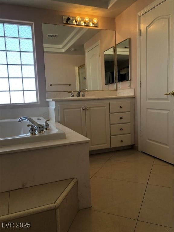 bathroom featuring visible vents, a garden tub, vanity, and tile patterned flooring