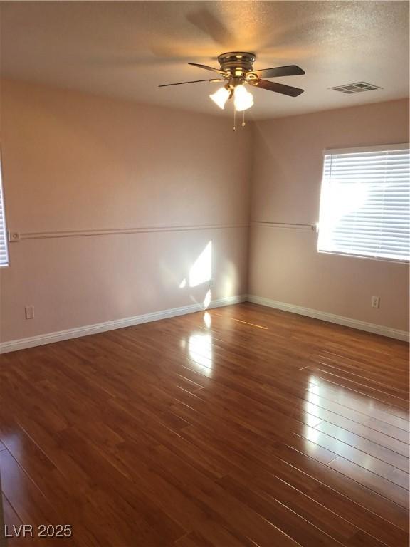 spare room with a ceiling fan, baseboards, and wood finished floors