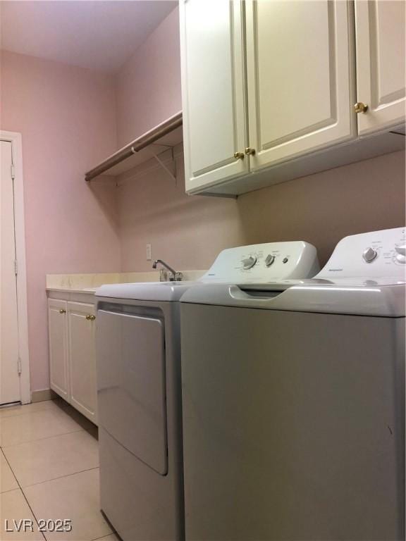 laundry area with cabinet space, independent washer and dryer, and light tile patterned flooring