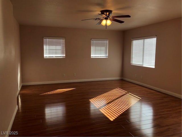 empty room featuring ceiling fan, baseboards, and wood finished floors