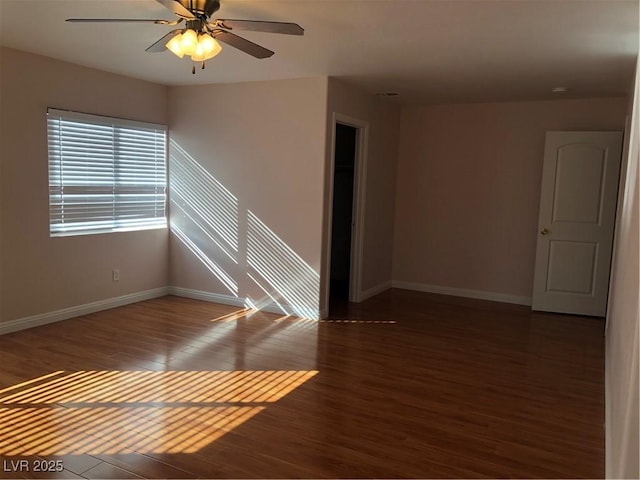 unfurnished room featuring ceiling fan, baseboards, and wood finished floors