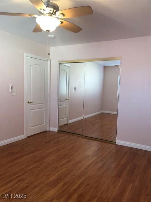 unfurnished bedroom with ceiling fan, a closet, baseboards, and wood finished floors