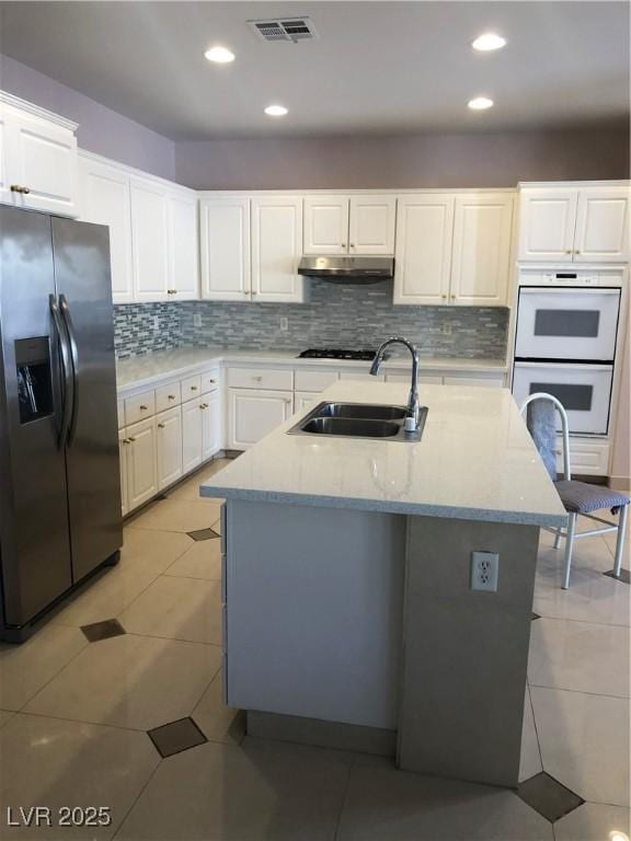 kitchen featuring visible vents, light tile patterned flooring, a sink, white cabinets, and stainless steel refrigerator with ice dispenser