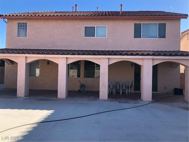 rear view of property with stucco siding and a patio