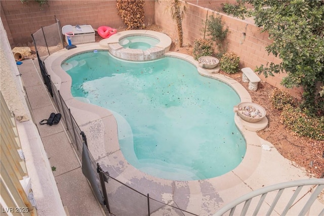 view of pool with a fenced backyard and a pool with connected hot tub