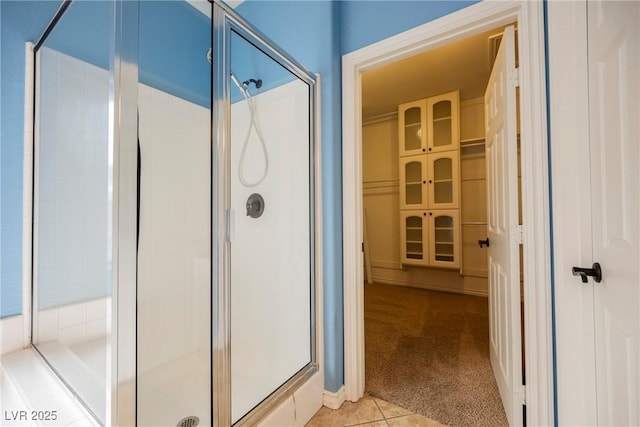 full bath with tile patterned floors and a shower stall