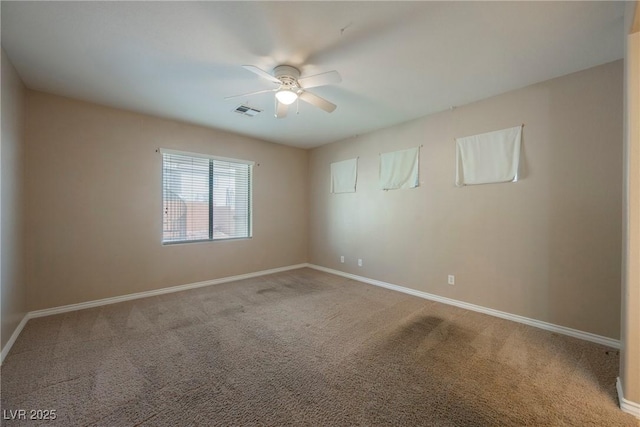 carpeted spare room featuring visible vents, baseboards, and ceiling fan