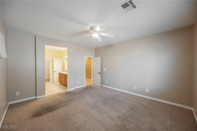 unfurnished bedroom featuring visible vents, baseboards, light colored carpet, and connected bathroom