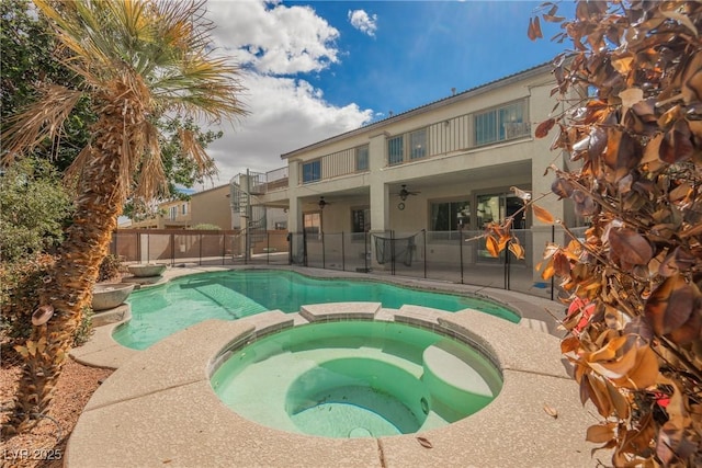 view of swimming pool with a fenced backyard, a patio, a pool with connected hot tub, and a ceiling fan