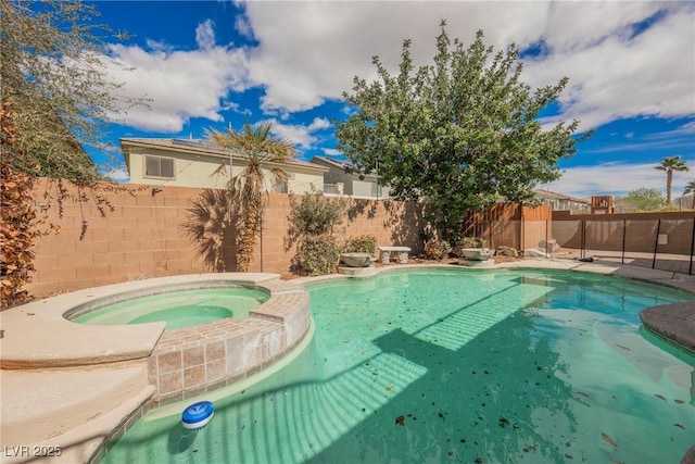 view of swimming pool featuring a pool with connected hot tub and a fenced backyard