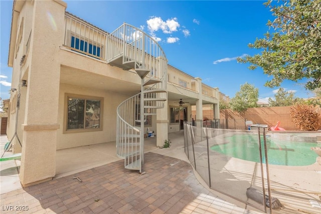 view of swimming pool featuring a fenced in pool, ceiling fan, stairs, a fenced backyard, and a patio