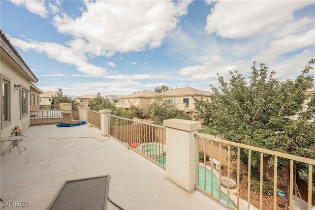 view of patio featuring a residential view, a balcony, and a pool