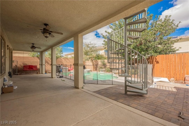 view of patio / terrace featuring stairway, a fenced backyard, a fenced in pool, and ceiling fan