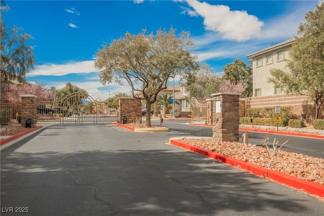 view of street with a gate, curbs, and a gated entry