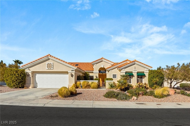 mediterranean / spanish house with a tile roof, stucco siding, concrete driveway, and a garage