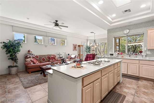 10548 Findlay Ave, Las Vegas, NV 89134 - kitchen featuring light countertops, ceiling fan, a kitchen island, a tray ceiling, and light brown cabinetry