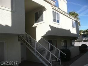 view of home's exterior with stucco siding and stairs