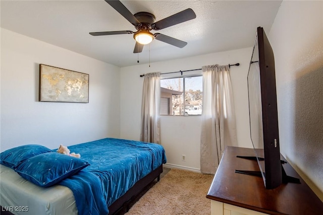 bedroom featuring light carpet, a ceiling fan, and baseboards