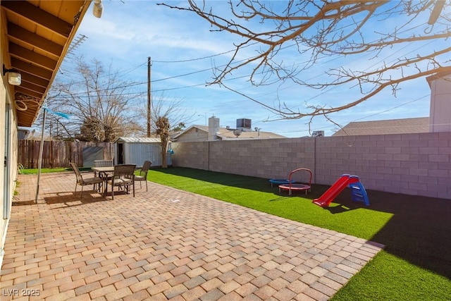 view of patio / terrace with central AC, a fenced backyard, and an outdoor structure