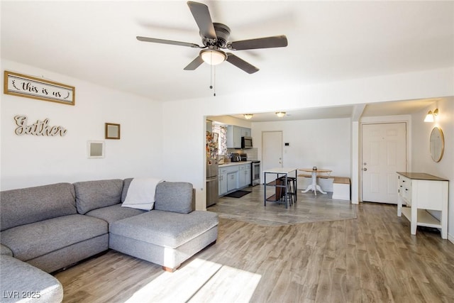 living room featuring light wood-type flooring and a ceiling fan