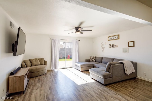 living area featuring visible vents, baseboards, wood finished floors, and a ceiling fan