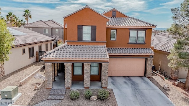 view of front of house featuring stucco siding, a tiled roof, an attached garage, and driveway