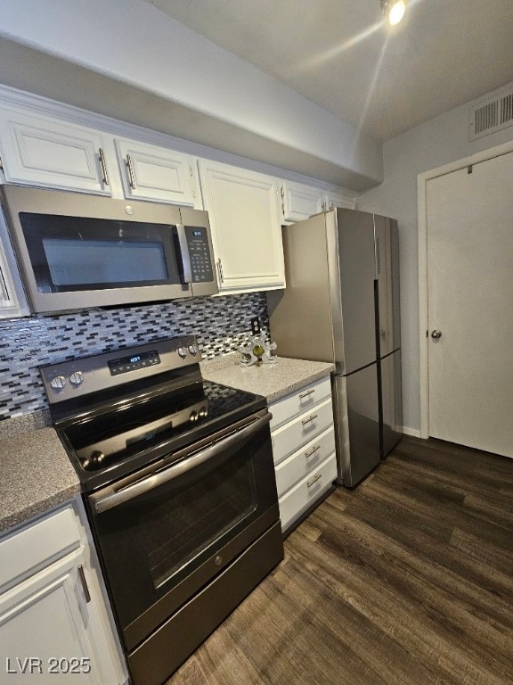 kitchen featuring visible vents, tasteful backsplash, dark wood-style floors, appliances with stainless steel finishes, and white cabinets