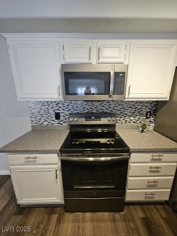 kitchen featuring stainless steel microwave, white cabinetry, dark wood-type flooring, and electric range