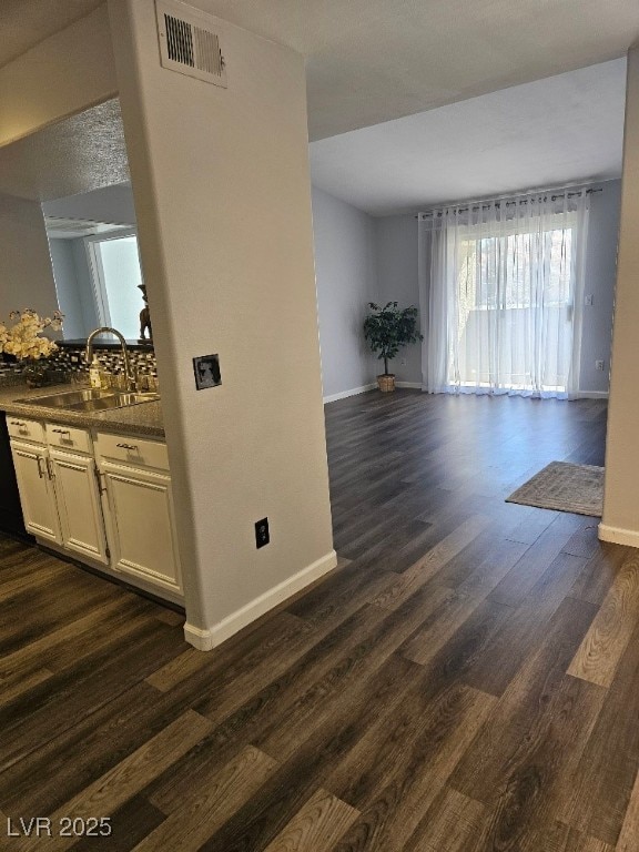 interior space featuring visible vents, baseboards, and dark wood-style floors