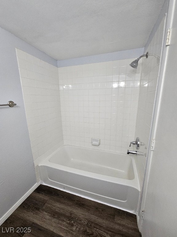 bathroom featuring baseboards, shower / washtub combination, and wood finished floors