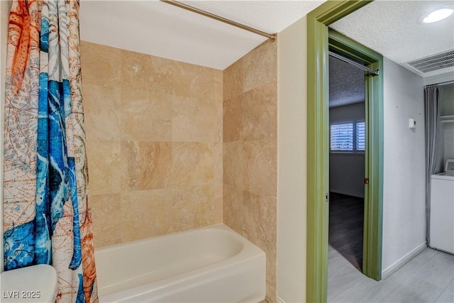 bathroom with visible vents, washer / dryer, shower / bath combo, a textured ceiling, and toilet