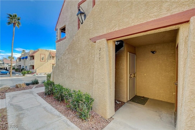 view of exterior entry featuring a residential view and stucco siding