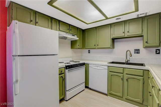 kitchen with visible vents, under cabinet range hood, a sink, white appliances, and green cabinetry