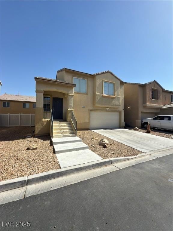 view of front of property with stucco siding, concrete driveway, a garage, and fence