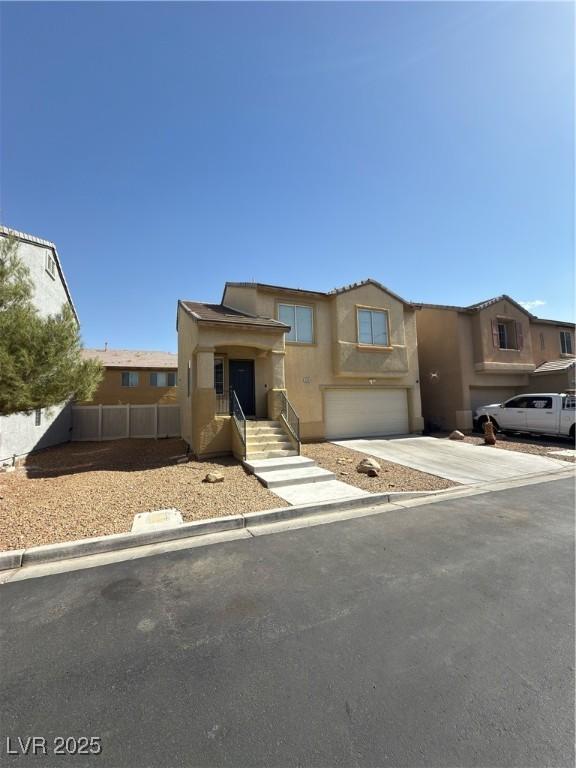 view of front of property featuring stucco siding, driveway, an attached garage, and fence