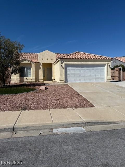 view of front of property featuring stucco siding, an attached garage, driveway, and a tile roof