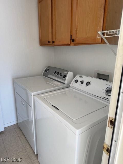 washroom with cabinet space, baseboards, and separate washer and dryer